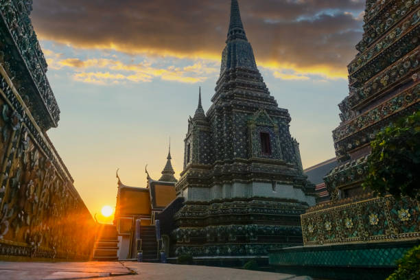 Ornate buddhist temple wat pho at sunset with sun shining through the ornate walls