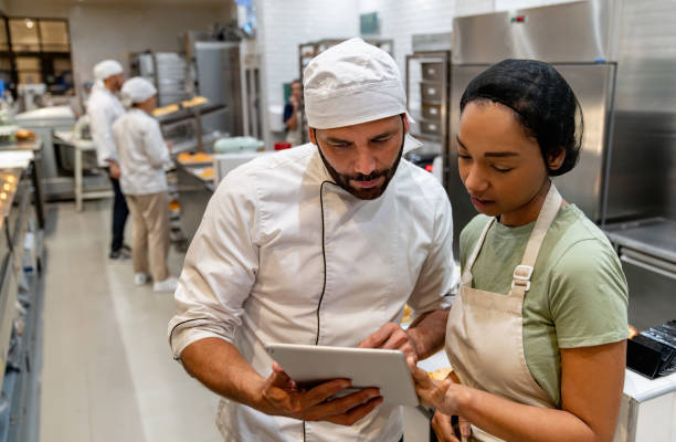 istock Employees working at the bakery and looking at a recipe on a tablet 2198555863