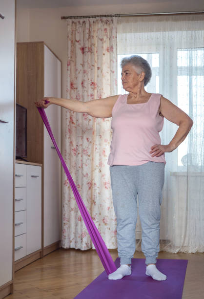 istock Senior woman doing home workout for mobility and rehabilitation. Elderly woman practicing stretching exercises at home on a yoga mat. prevention of osteoporosis. easy cardio training. copyspace 2198556878