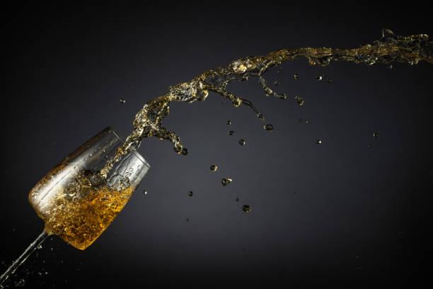 istock Glass and white wine splash on a black background. 2198561800