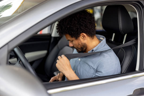istock Man fastening his seat belt in a car 2198562586