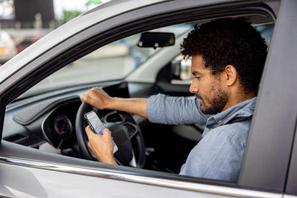 istock Man in his car using a GPS app on his cell phone 2198562588