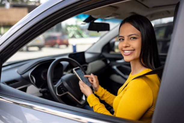 istock Happy woman in her car using a navigation app on her cell phone 2198562599