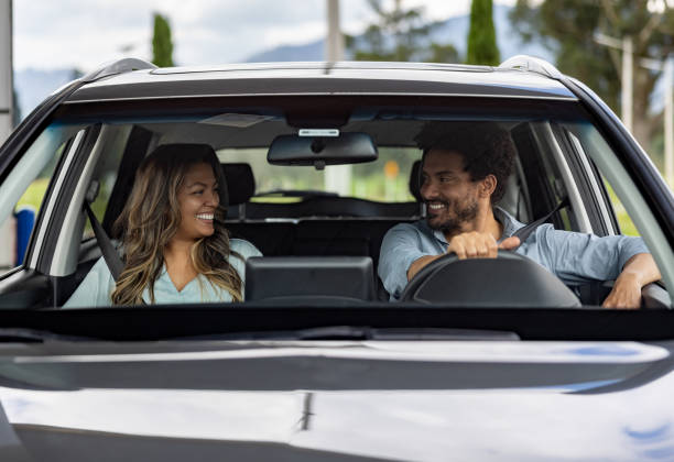 istock Happy couple smiling in their car while driving 2198562606