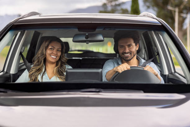 istock Happy couple smiling in their car while going on a road trip 2198562641