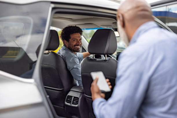 fotografii de stoc, fotografii și imagini scutite de redevențe cu șofer de taxi care ridică un pasager și zâmbește - mers cu maşina