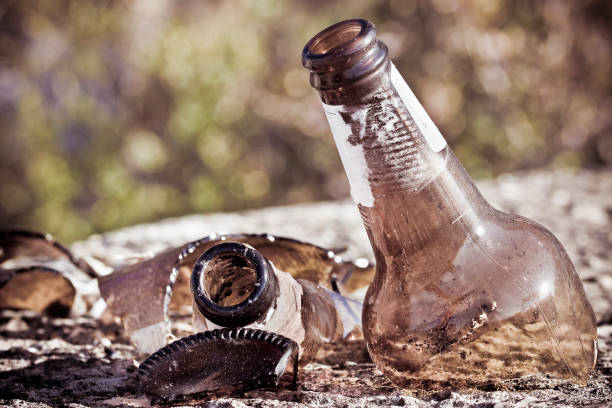 istock Shattered beer bottle resting on the ground: alcoholism concept - toned image 2198564413