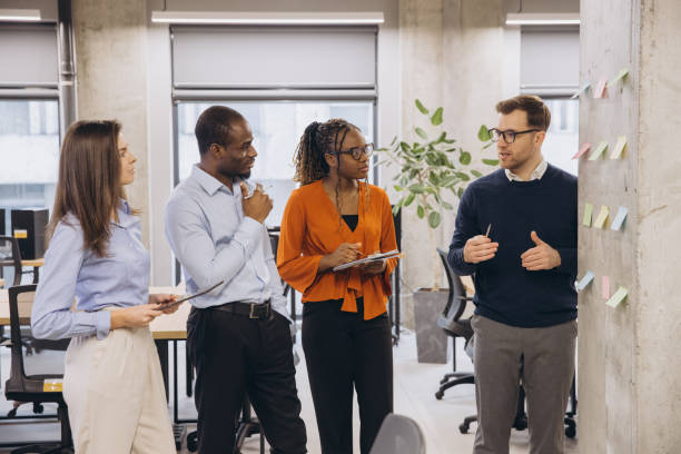 istock Group of diverse business people discussing new ideas using sticky notes during a productive meeting in a modern office environment 2198564425
