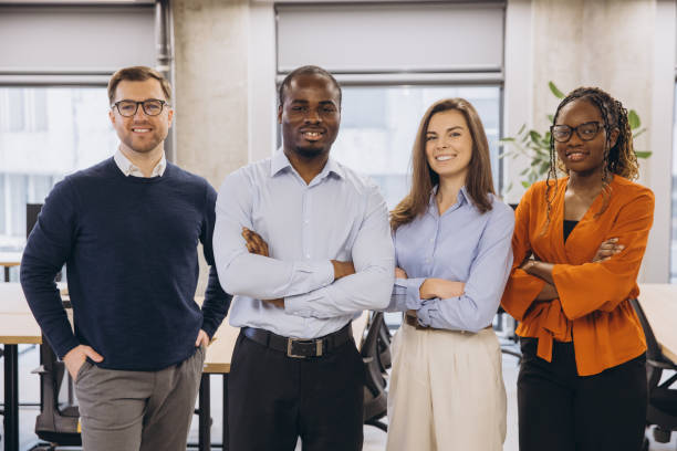 istock Multi ethnic businesspeople standing together with arms crossed, showing teamwork and confidence in a bright office environment 2198564473