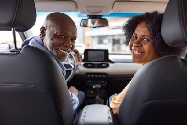 istock Senior couple in a car smiling and looking back at the camera 2198565855