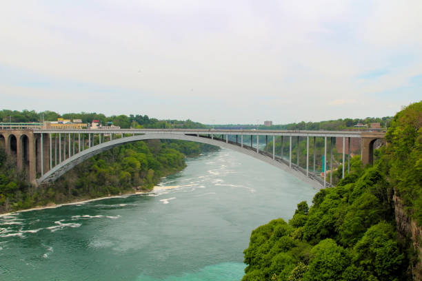 A bridge spans a river bordered by lush trees and gentle waters.