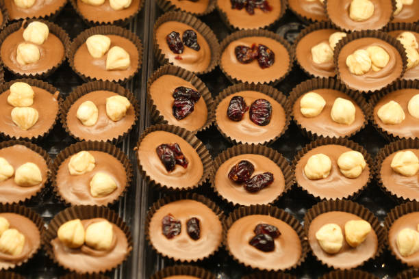 A tempting display of chocolate cups topped with nuts and colorful dried fruits
