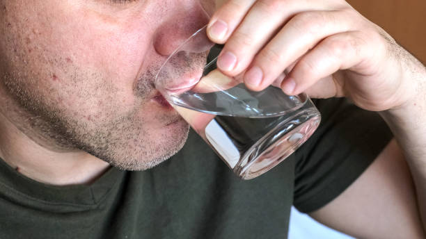 istock Close up mature man drinking water from glass indoors 2198569019