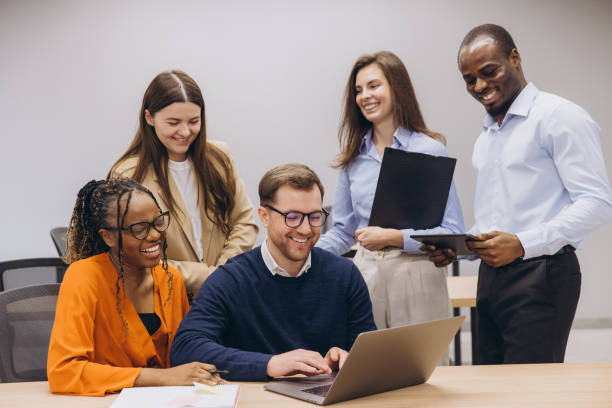 istock Group of diverse professionals engaged in a collaborative work session, sharing ideas and using technology in a modern office environment 2198569939