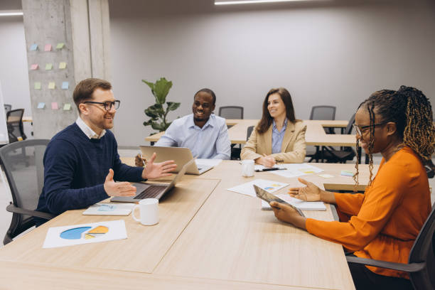 istock Diverse professionals collaborating, reviewing data charts and digital devices during strategic planning session in modern workplace setting 2198569959
