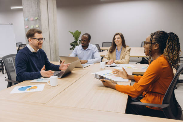 istock Professional business team analyzing data charts, working together at sleek conference table, sharing strategic insights during collaborative meeting 2198569965