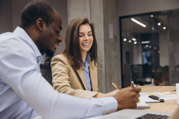 istock Two business professionals collaborating on a project in a modern office environment, highlighting teamwork and diversity in the workplace 2198570575