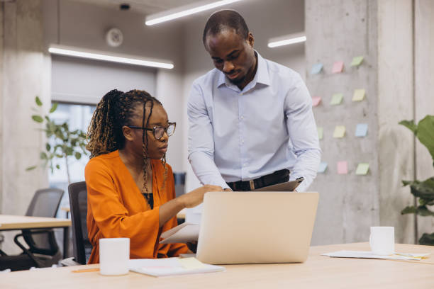 istock African american professional team collaborating on project, working together with modern technology in bright, open workspace, highlighting creativity and teamwork 2198570763