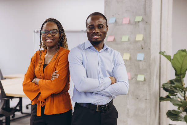 istock Two african american business professionals standing confidently in a modern office, showcasing teamwork and diversity with a backdrop of colorful sticky notes 2198570794