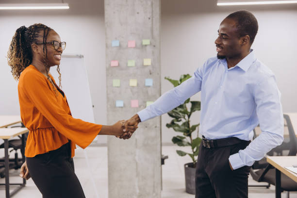 istock Business african american professionals shaking hands near modern workspace, representing successful partnership and corporate collaboration 2198570805