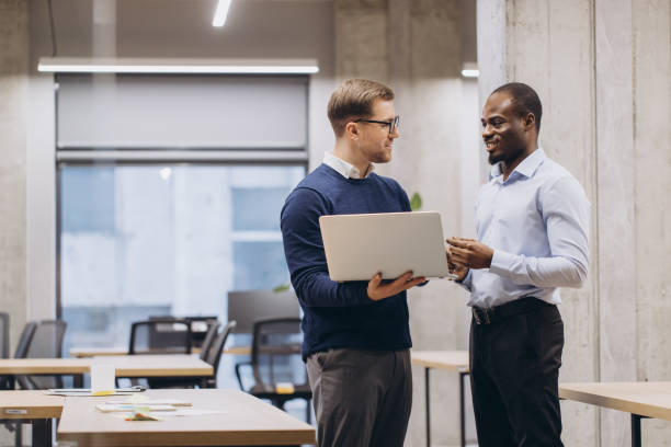istock Business professionals discussing project details, working together on laptop in modern office environment, representing teamwork and innovation 2198570931