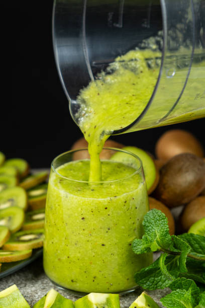 istock Fresh green kiwi smoothie pour from blender bowl into glass 2198571286