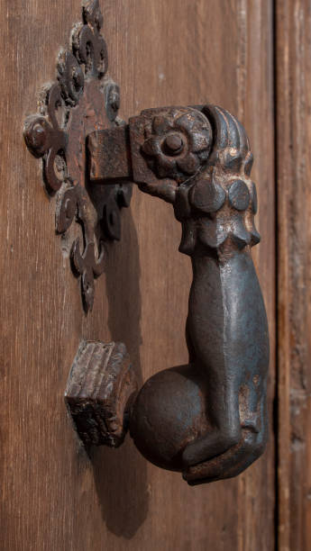 istock One-handed knocker on an antique door 2198571344