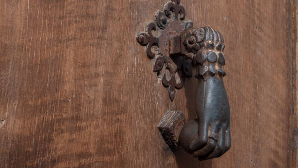 istock One-handed knocker on an antique door 2198571385