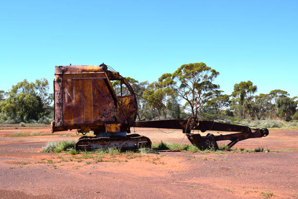 A rusted excavator sits abandoned in the harsh Western Australian desert near Kalgoorlie, a relic of past mining operations.