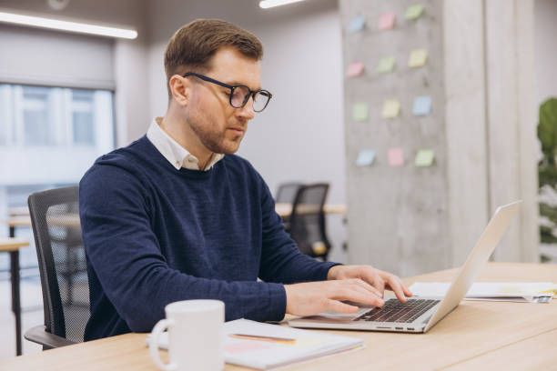 istock Professional typing on laptop, focused amid colorful sticky notes decorating sleek workspace background 2198573398