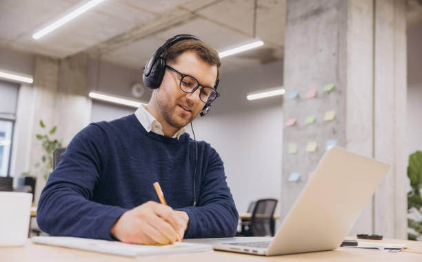 istock Professional employee participating in virtual conference, typing notes on laptop within contemporary, tech enabled work environment 2198573580
