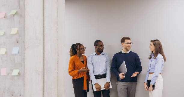 istock Professional colleagues brainstorming, sharing insights, collaborating in modern workplace with glass walls, laptops, dynamic interaction 2198573583