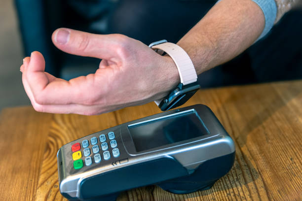 istock Man using a smartwatch for contactless payment at a payment terminal 2198575760