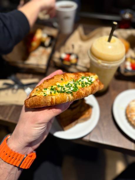 istock Croissant sandwich with egg holding in hand at cafe shop 2198576399