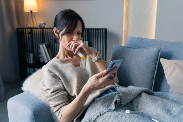 istock Young woman with cold symptoms sitting on sofa at home 2198579319