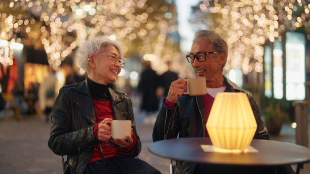 istock Senior Couple Enjoying Warm Drinks Under Festive Lights 2198586083