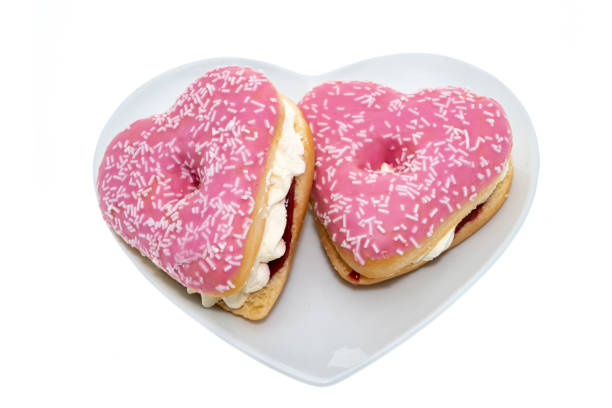 Pink iced heart shape cream filled doughnuts cake - white background