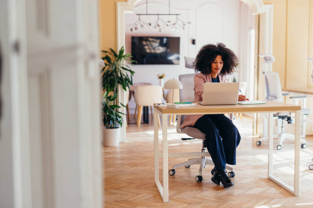 istock Young manager working on a laptop and taking notes in her office 2198589593