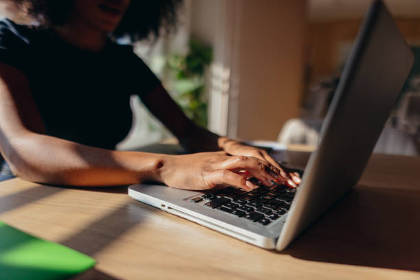 istock Young woman typing on laptop keyboard working from home 2198589726