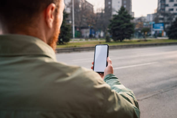 istock Man on a bus station, looking at his phone 2198589846