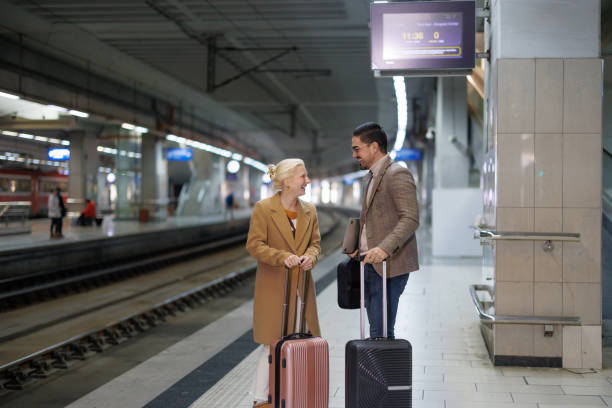 istock Business People Talking at the Railroad Station while Waiting for the Train 2198589901
