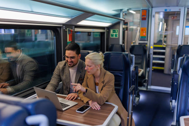 istock Business partners working on a laptop while traveling by train 2198589971