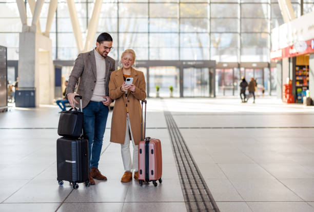 istock Young couple looking at smartphone while waiting for their train at railroad station 2198593379