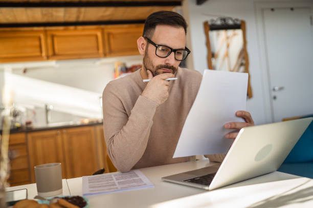 istock Adult man read and look document work at home paper work 2198594777
