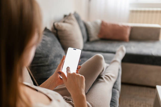 istock Woman relaxing at her home and using a mobile phone 2198598981