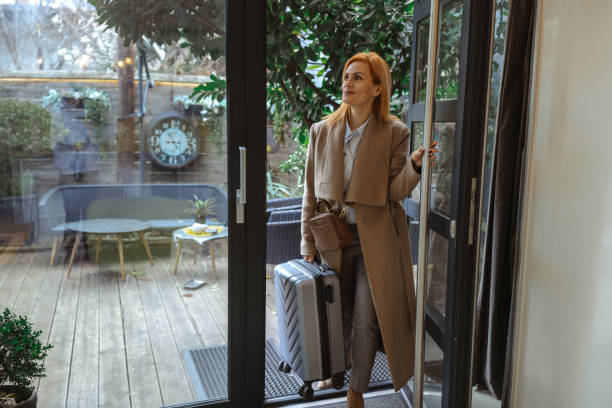 istock Business professional entering a modern home with a suitcase in hand 2198599343
