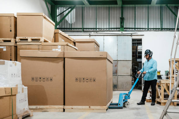 istock Industrial manager using a pallet truck in the warehouse 2198599617