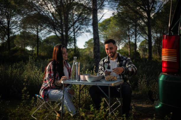 istock Happy couple enjoying a meal outdoors while camping 2198601693