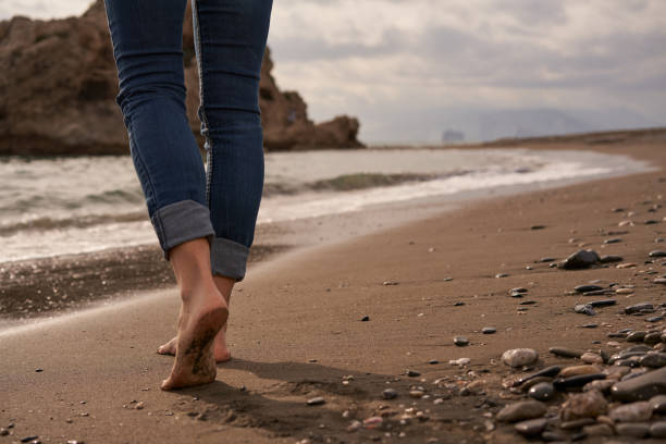 istock Walking Barefoot Along a Serene Shoreline at Dusk, Feeling the Cool Sand and Gentle Waves Embrace the Feet 2198601708