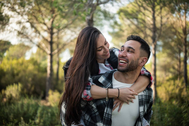 istock Happy young couple piggybacking in a forest, enjoying a romantic walk 2198601734